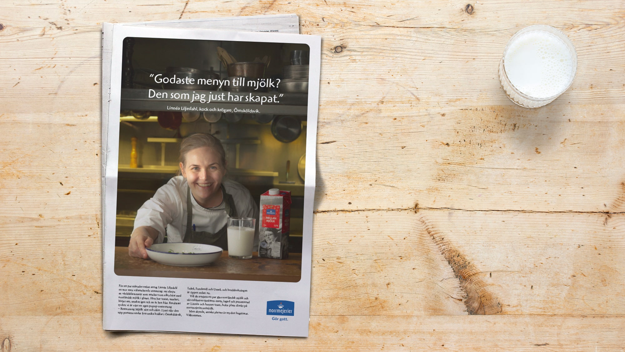 Newspaper with an ad for Milk put on wooden table with glass of milk
