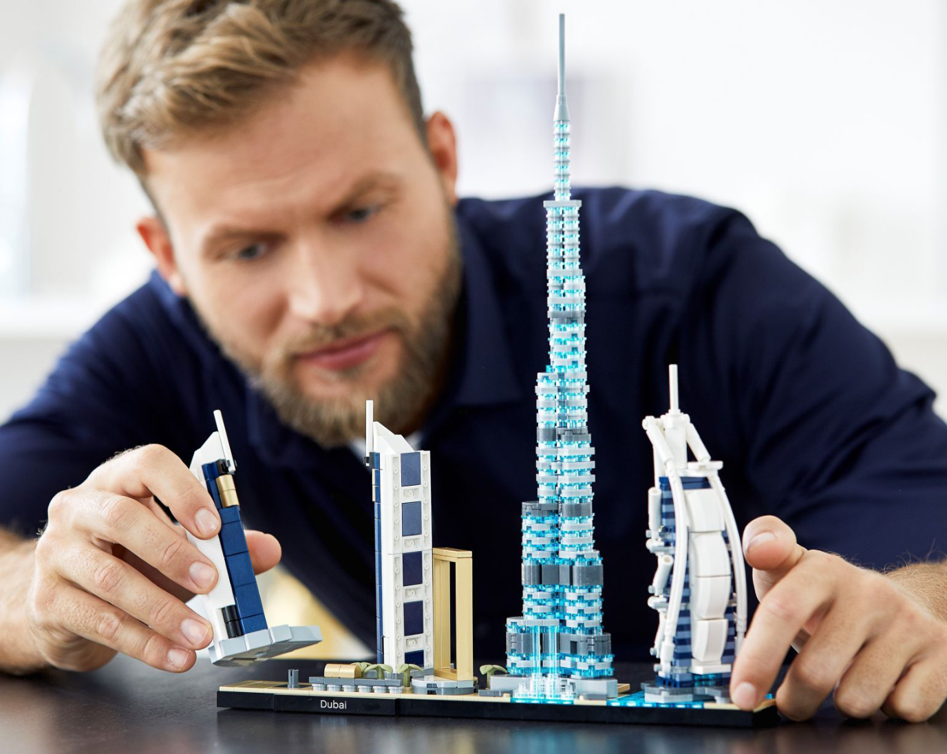 Adult building Dubai skyscrapers with LEGO bricks